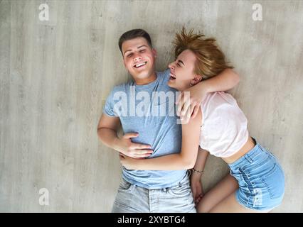 Happy young couple at home détente sur le plancher Banque D'Images