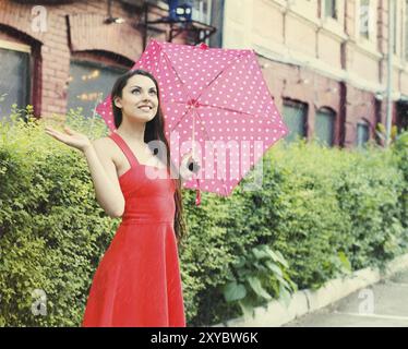 Portrait de belle jeune fille marcher avec parapluie sous la pluie Banque D'Images