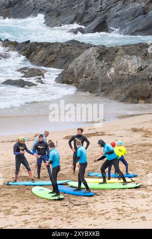 Des instructeurs de surf guident les enseignants du Surf Sanctuary enseignant un groupe d'apprenants novices de surf sur Fistral Beach à Newquay en Cornouailles au Royaume-Uni Banque D'Images