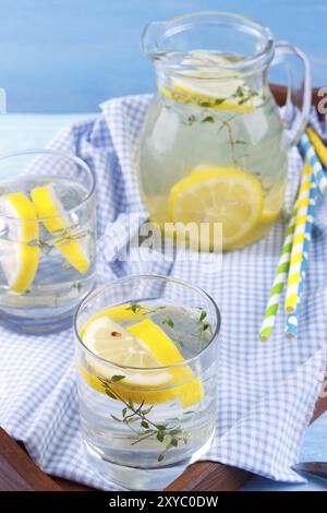 Boisson fraîche avec du citron et le thym dans un bac bleu sur fond de bois Banque D'Images