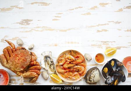 Variété de fruits de mer fraîchement préparés sur la table de cuisine en bois blanc. Vue d'en haut Banque D'Images