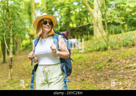 Portrait d'une femme caucasienne décontractée routard marchant le long d'une forêt seule profitant de la nature Banque D'Images