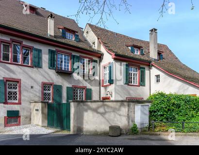 Belles maisons anciennes dans l'Alstadt Grossbasel de Bâle, (vieille ville du Grand Bâle), Suisse. Avec peinture marron traditionnelle et volets verts. Banque D'Images