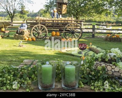 Bougies au premier plan, en arrière-plan une ferme décorée d'automne avec tracteur et citrouilles, borken, muensterland, Allemagne, Europe Banque D'Images