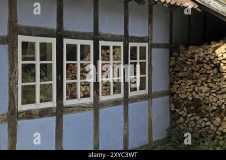 Maison bleue à colombages et pile de bois de chauffage Banque D'Images