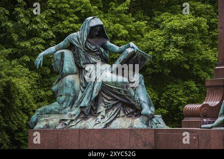 Statue féminine lisant un livre assise sur un sphinx féminin Banque D'Images