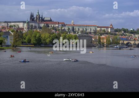 Vue sur la vieille ville colorée et le château de Prague avec la rivière Vltava et les bateaux sur elle Banque D'Images