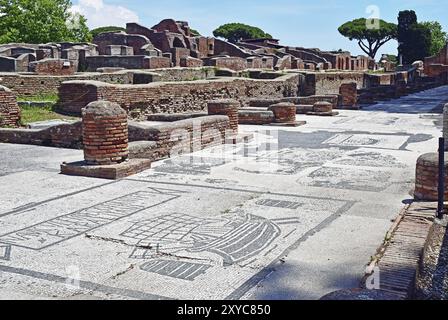 Mosaïque avec des motifs maritimes, en arrière-plan les restes des murs de l'ancienne ville d'Ostie Banque D'Images