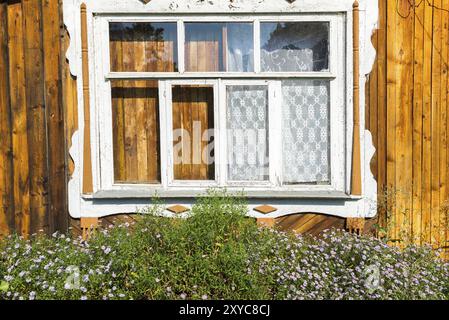 Fenêtre sculptée dans la vieille maison de campagne en bois russe Banque D'Images