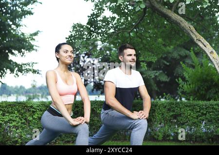 Jeune couple exercising happpy et étirer les muscles avant l'activité sportive Banque D'Images