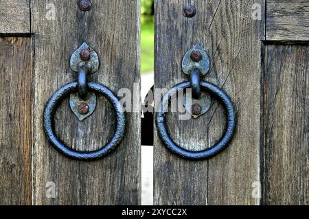 Ancienne porte en bois avec deux anneaux de frappe de porte en gros plan Banque D'Images