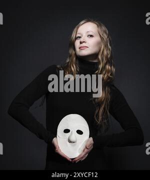 Touche Bas portrait d'une belle femme aux cheveux longs holding mask Banque D'Images