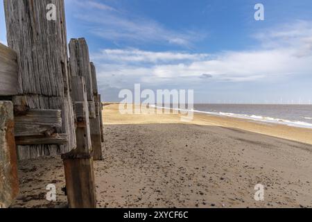 La plage de Great Yarmouth, Norfolk, Angleterre, Royaume-Uni, avec la jetée sur la gauche et quelques éoliennes du parc éolien de Scroby Sands dans la mer du Nord Banque D'Images