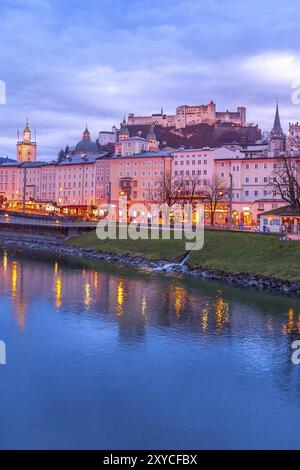 Salzbourg, Autriche au crépuscule avec vue sur la Cathédrale illuminée et Festung Hohensalzburg castle, reflet dans la rivière Salzach Banque D'Images