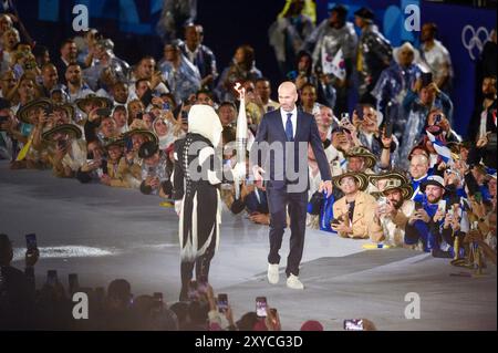 PARIS, FRANCE-26 juillet 2024 : L'ancien footballeur français Zinedine Zidane (R) tient la flamme olympique au Trocadéro lors de la cérémonie d'ouverture de Banque D'Images