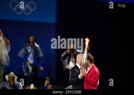 PARIS, FRANCE-26 juillet 2024 : L'ancien footballeur français Zinedine Zidane (G) remet la flamme olympique au joueur de tennis espagnol Rafael Nadal au t Banque D'Images