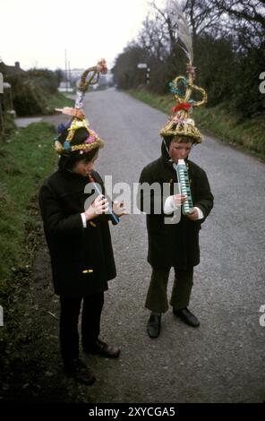 Deux jeunes Biddy Boys portant la coiffe traditionnelle. Un garçon a un sifflet de Penny et l'autre un ?????? Ils marchent d'un chalet à l'autre pour célébrer la Sainte Brigit celtique ou Brigid, qui était une déesse païenne de l'Irlande pré-chrétienne. Le 1er février est son jour des Saints. Killorglin, County Kerry, Irlande du Sud février 1972 1970s Eire HOMER SYKES . Banque D'Images