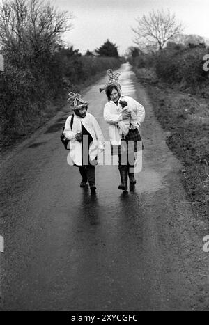 Irlande des années 1970, deux Biddy Boys frère et sœur habillés et célébrant de manière traditionnelle la Sainte Brigit celtique ou Brigid, qui était une déesse de l'Irlande pré-chrétienne. Le 1er février est son jour des Saints. Ils marchent d'un chalet à l'autre. Killorglin, County Kerry, Eire, Irlande du Sud février 1972 Eire HOMER SYKES Banque D'Images