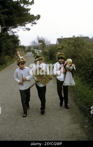 Irlande des années 1970, trois Biddy Boys habillés et célébrant de manière traditionnelle la Sainte Brigit celtique ou Brigid, qui était une déesse de l'Irlande pré-chrétienne. Le 1er février est son jour des Saints. Ils marchent d'un chalet à l'autre. L'un des garçons porte une poupée pour enfants qui représente St Brigit. Killorglin, County Kerry, Eire, Irlande du Sud février 1972 Eire HOMER SYKES Banque D'Images