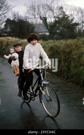 Killorglin, Comté de Kerry années 1970 Deux jeunes Biddy Boys célébrant le Saint Celtique, St Brigit ou Saint Brigid, le 1er février est sa Fête des Saints. La poupée de l'enfant représente l'effigie de Sainte Brigit et est connue sous le nom de Biddy. Eire, Irlande du Sud 1972. HOMER SYKES Banque D'Images