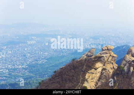 Vue du paysage urbain de Séoul depuis le sommet de la montagne Bukhansan où le smog et la pollution de l'air empêchent les bâtiments de vue dégagée dans la vallée ci-dessous Banque D'Images