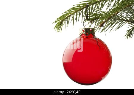 Boule rouge d'arbre de noël suspendue à la feuille d'épicéa Banque D'Images