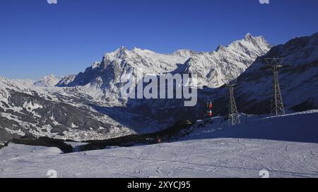 Piste de ski, téléphérique et montagnes enneigées Finsteraarhorn et Schreckhorn. Journée de ski à Grindelwald, Suisse, Europe Banque D'Images