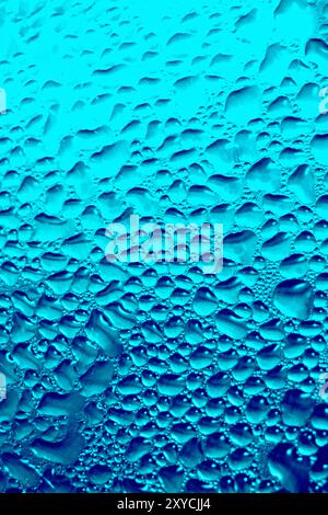 Photographie d'art. Gouttelettes d'eau sur la vitre en verre. Banque D'Images