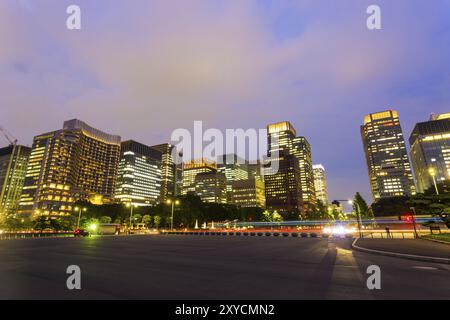 Centre-ville Marunouchi District skyline et circulation la nuit, gratte-ciel fenêtres éclairées sous un ciel crépusculaire à Tokyo, Japon, Asie Banque D'Images