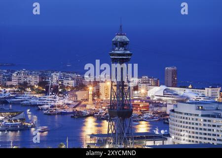 Horizon de Barcelone la nuit, tour Torre de Jaume I, maisons et immeubles d'appartements entre Port Vell et mer Méditerranée en Catalogne, Espagne, E Banque D'Images