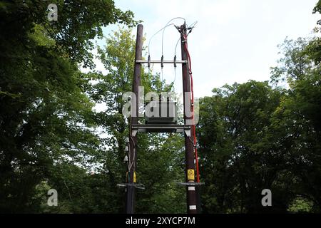 Lignes électriques et transformateur sur poteaux télégraphiques en bois Banque D'Images