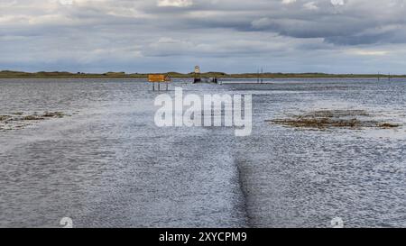 Près de Beal, Northumberland, Angleterre, Royaume-Uni, septembre 08, 2018 : route inondée vers l'île Sainte de Lindisfarne avec une voiture qui vous attend Banque D'Images