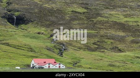 Ferme solitaire en islande avec grand paysage une cascade en arrière-plan Banque D'Images