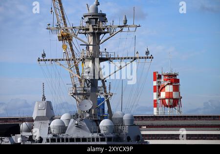 Honolulu, États-Unis. 31 juillet 2024. Un navire de guerre de la Navy est amarré devant la tour d'eau rouge et blanche lors de l'exercice militaire Rim of the Pacific (RIMPAC, juin 26) dirigé par les États-Unis à Pearl Harbor. Crédit : Soeren Stache/dpa/Alamy Live News Banque D'Images