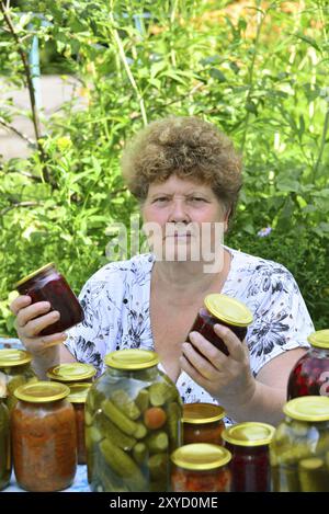 Femme au foyer mature avec une nourriture en conserve pour l'hiver Banque D'Images