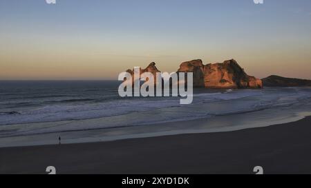 Le coucher du soleil d'observation touristique à Wharariki Beach Banque D'Images