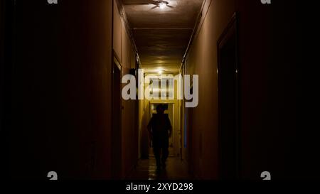 Figure effrayante dans un couloir sombre. Banque D'Images