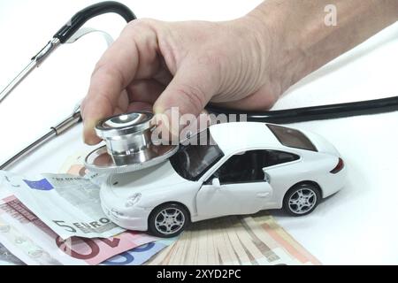 Stéthoscope avec voiture et les billets en euro sur un fond blanc Banque D'Images