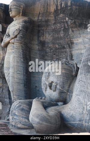 Deux statues monolithiques de Bouddha, Gal Viharaya, l'une debout et l'autre couchée, sont sculptées dans un seul morceau de granit strié à Polonnaruwa, l'an Banque D'Images