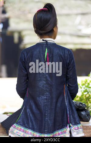 Biasha, Chine, 17 septembre 2007 : arrière d'une femme de la minorité ethnique Miao en veste bleue traditionnelle et chignon tressé à l'avant au village Miao de Bia Banque D'Images