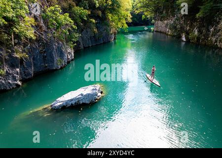 Femme touristique sur un voyage de SUP, planchiste de paddle explorant, pagayant le canyon de Soca et la rivière Idrijca près de Most na Soci, Slovénie Banque D'Images