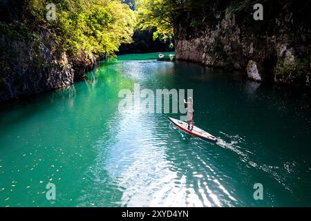 Femme touristique sur un voyage de SUP, planchiste de paddle explorant, pagayant le canyon de Soca et la rivière Idrijca près de Most na Soci, Slovénie Banque D'Images