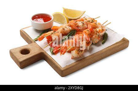 Délicieuses brochettes de crevettes grillées avec sauce et citron vert isolées sur blanc Banque D'Images