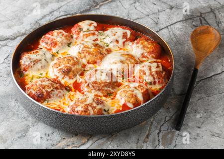 Casserole italienne de boulettes de viande cuites au four dans une sauce tomate épicée avec fromage mozzarella et thym gros plan dans un plat de cuisson sur la table. Horizontal Banque D'Images