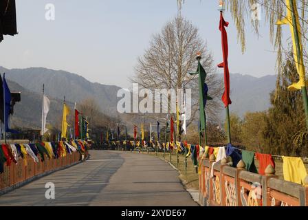 Route d'entrée à Trashi Chhoe Dzong, Thimphu, Bhoutan avec drapeaux au coucher du soleil la lumière Banque D'Images