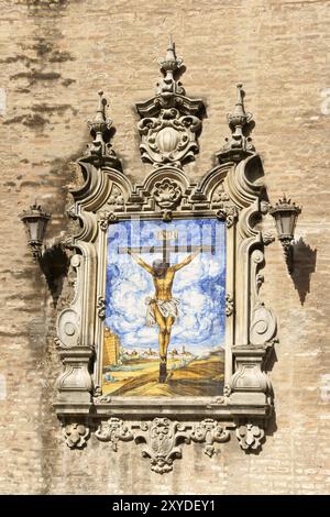 Azulejo montrant Jésus sur la croix d'un mur extérieur de l'église de l'Annonciation (Iglesia de la Anunciacion) à Séville, Espagne. L'église, in Banque D'Images