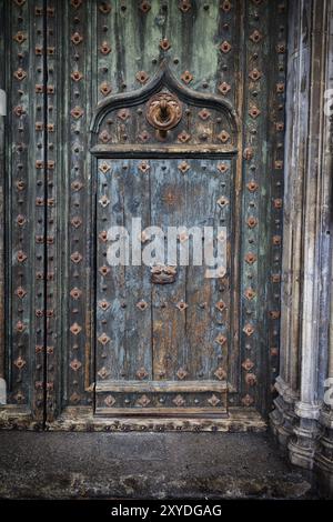 Vieille porte dans la porte de la cathédrale de Gérone en Espagne, bois vieilli avec armature métallique et deux batteurs Banque D'Images