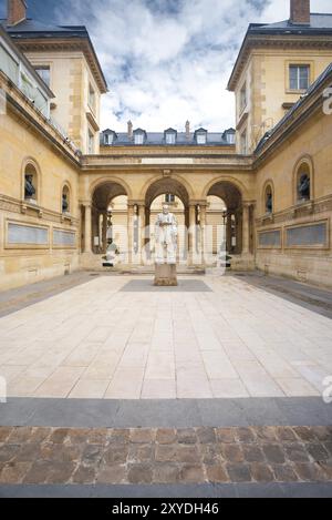 Architecture traditionnelle dans une belle cour ancienne du Collège de France, près de la Sorbonne en France. Photo prise depuis le trottoir public Banque D'Images