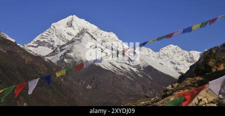 Scène près de Namche Bazaar, Népal. Drapeaux de prière et montagnes enneigées Banque D'Images