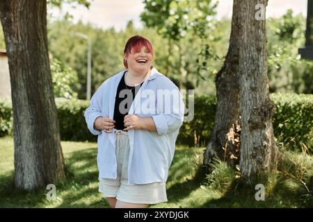 Une femme de grande taille se promène dans un parc, souriant rayonnamment. Banque D'Images